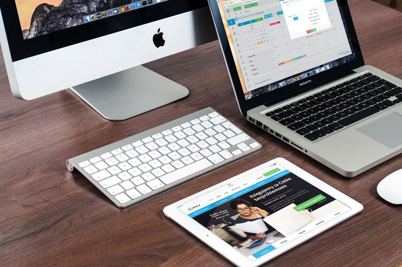 Un bureau élégant et épuré, équipé d’appareils Apple : iMac, MacBook et iPad.